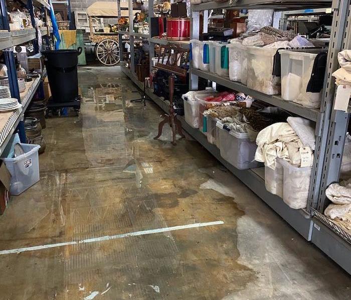 Warehouse with random items on shelves and water on the floor